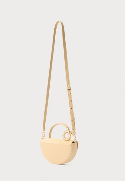 Borsa a tracolla beige con forma curva a mezzaluna, dotata di manico a spirale e tracolla regolabile. Texture liscia con dettagli di cucitura sottili.