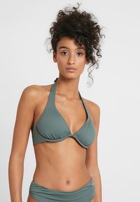 Triangular biustonosz bikini w stonowanej zielonej tkaninie, miękka tekstura, projekt na szyję z marszczonym środkiem i minimalistycznym stylem.