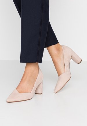 Bežové semišové lodičky na vysokém podpatku s špičatou špičkou a designem ve tvaru V, s masivním podpatkem a hladkou texturou. Vhodné pro formální nošení.