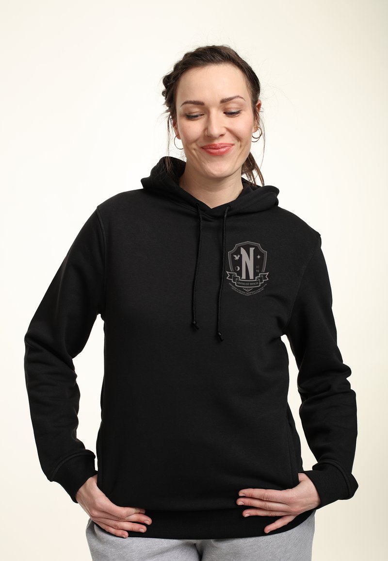 Felpa nera con cappuccio, tasca frontale, cappuccio regolabile con cordino e patch logo sul petto. Realizzata in tessuto morbido con una texture liscia.