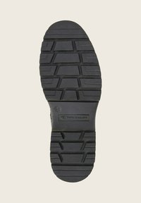 Suela de zapato de goma negra con un patrón de textura para tracción, con un logotipo rectangular y la talla "45" marcada.