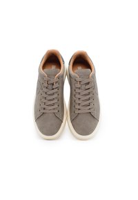 Sneakers in suede grigio con suole in gomma crema, caratterizzati da lacci tondi, patch con logo e una fodera interna color nocciola. Design e costruzione minimalisti.