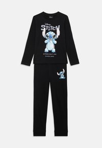 Černý pyžamový set se zeleným tričkem s dlouhým rukávem a grafikou Stitch s textem. Kalhoty mají shodnou potisk Stitch na bocích. Měkká, pohodlná tkanina.