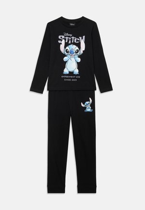 Črni pižama set, ki vključuje dolgi rokav z grafiko in besedilom Stitch v modri barvi. Hlače imajo usklajen print Stitch na bokih. Mehka in udobna tkanina.