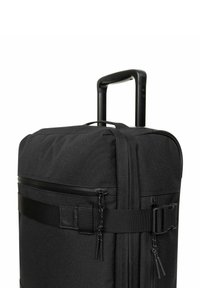 Černý kufr na kolečkách s texturovaným textilním povrchem, dvojitými zipy, nastavitelným popruhem a výsuvnou rukojetí pro snadnou přepravu.