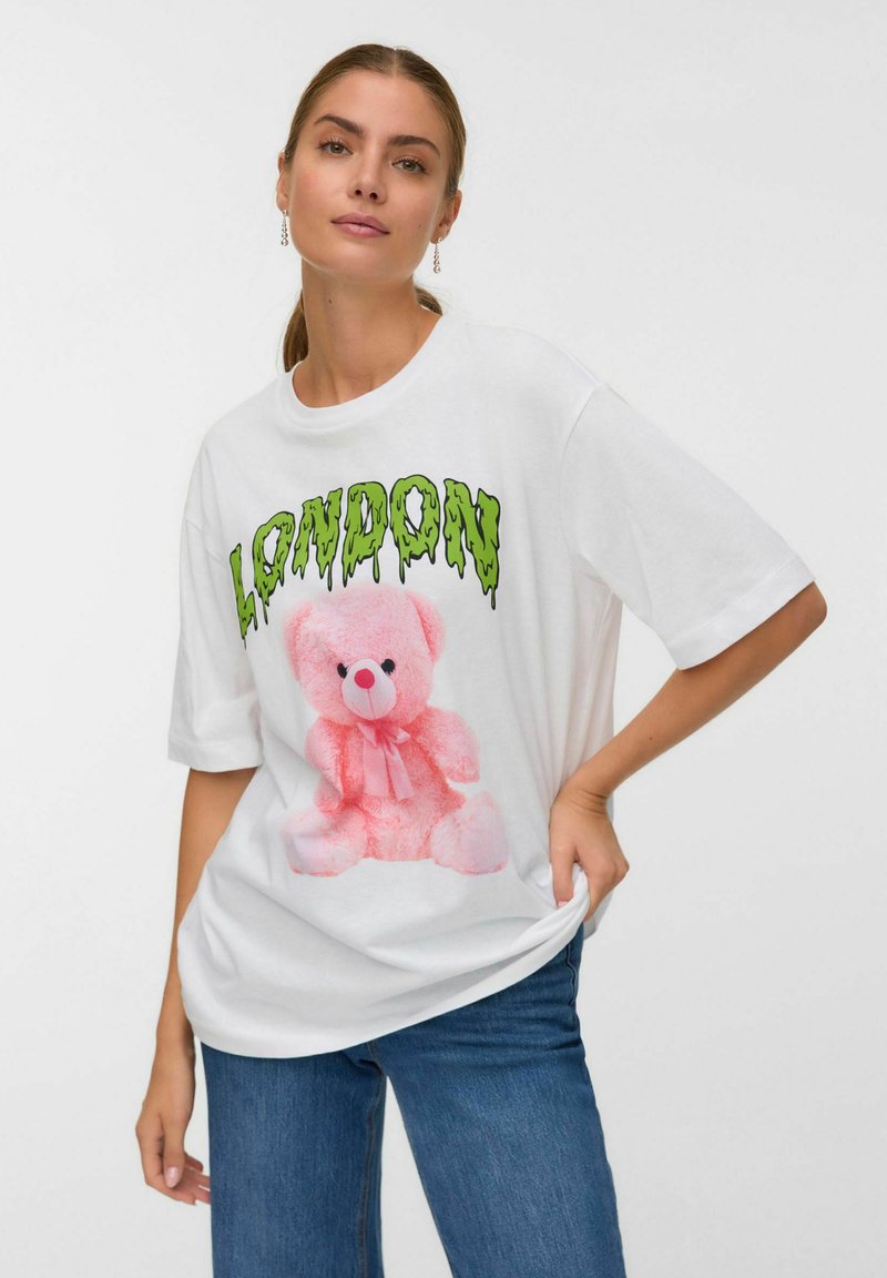 Witte katoenen T-shirt met een afbeelding van een roze teddybeer en groene tekst "LONDON". Losse pasvorm met brede mouwen. Casual ontwerp.