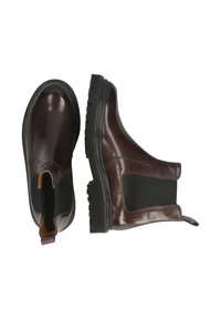 Botas Chelsea de cuero marrón con paneles laterales elásticos, puntas redondeadas, suelas de goma texturizadas y asas para facilitar el calzado.