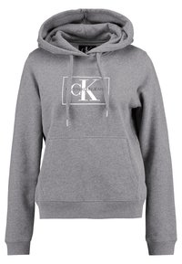Sudadera con capucha gris, hecha de una mezcla de algodón, que cuenta con un bolsillo tipo canguro en el frente, dobladillo acanalado y un logo blanco de Calvin Klein en el pecho.