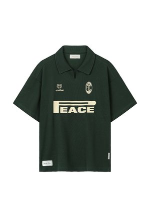 Dunkelgrünes kurzärmeliges Poloshirt mit cremefarbenem "PEACE"-Aufdruck, zwei kleinen Logos darüber und Kragen mit mittiger Einkerbung.