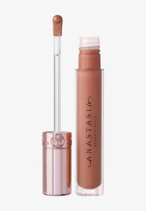 Liquid lipstick in a clear tube with a rose-gold lid, featuring a soft applicator wand. Shade: nude brown. Brand name in black text.