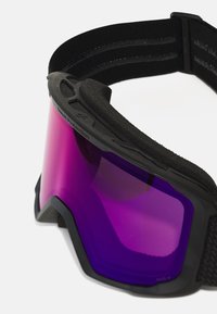 Ochelari de protecție cu ramă neagră și curea elastică. Au un lentil mare, de culoare violet, și umplutură din spumă texturată în jurul marginilor.