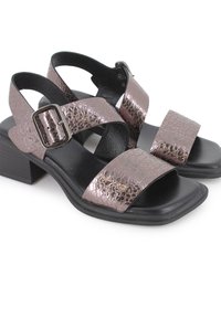 Sandalias de tacón bloque con correas texturizadas en rosa dorado metálico, hebilla ajustable y plantilla y suela de cuero negro. Diseño de punta cuadrada.