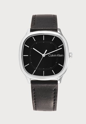Reloj de pulsera Calvin Klein negro con caja cuadrada de plata, marcadores de hora blancos simples y correa de cuero negra, mostrando la hora 10:10.