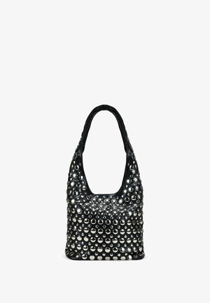 Bolso de hombro de cuero negro con un asa redondeada, cubierto de tachuelas plateadas brillantes de varios tamaños.