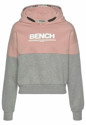 Sweat à capuche avec parties supérieures roses et parties inférieures grises, avec le texte ""BENCH STUDIO"" sur la poitrine et des cordons noirs à la capuche.