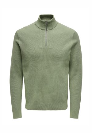 Grüner Pullover aus geripptem Strick mit hohem Kragen und halbem Reißverschluss. Weiche Textur und figurbetontes Design, mit langen Ärmeln und geradem Saum.