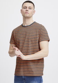 Striped t-shirt with orange and grey horizontal lines, crew neck, short sleeves, and a relaxed fit. Fabric appears soft with a casual look.