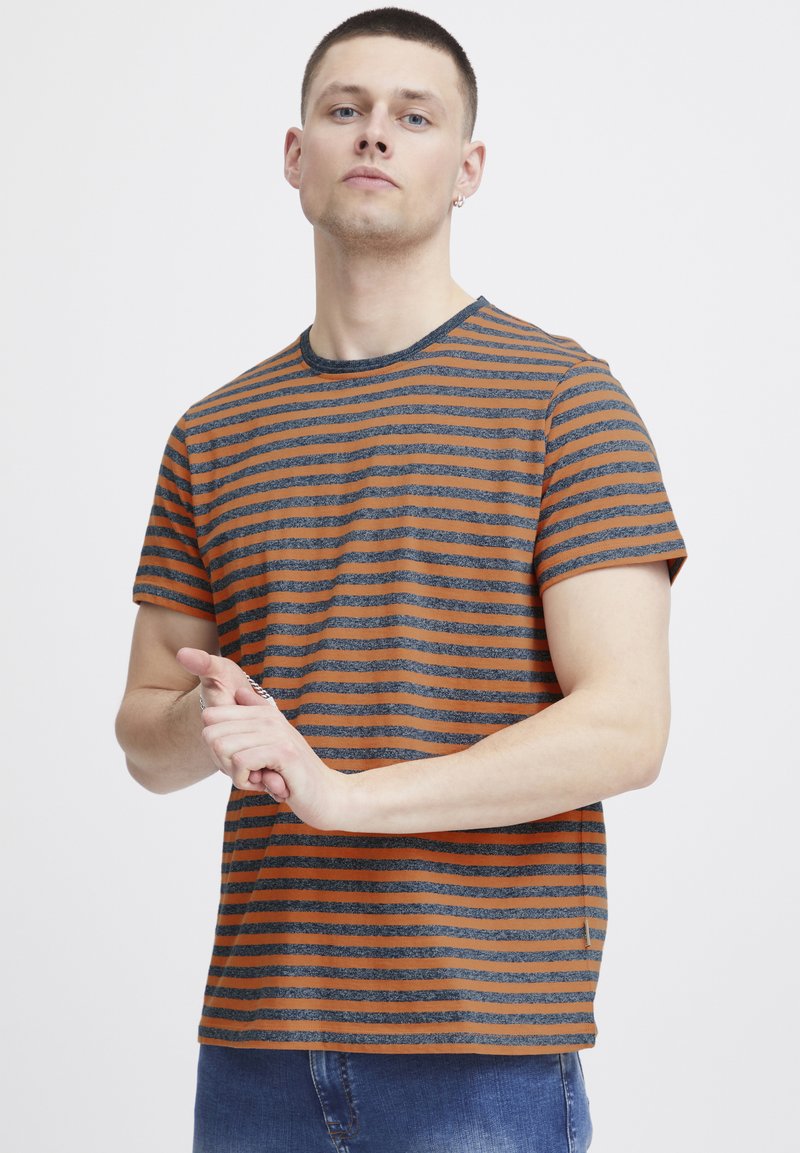 Striped t-shirt with orange and grey horizontal lines, crew neck, short sleeves, and a relaxed fit. Fabric appears soft with a casual look.