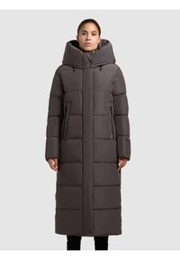 Long, puffy coat in dark gray fabric. Features a high collar, adjustable hood, two side pockets, and vertical quilted pattern.