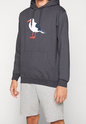 Gray hoodie featuring a seagull graphic in white, blue, and red, with a front pocket and drawstring hood. Paired with gray shorts.