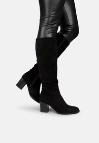 Zwarte kniehoge laarzen van zacht suede, met een blokhak en een ritssluiting aan de zijkant, bijzonder elegant en aansluitend van ontwerp.