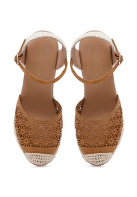 Sandalías de esparto de ganchillo marrones con punta abierta, tira en el tobillo y capuchón de dedo tejido. Patrón floral texturizado en el material superior.