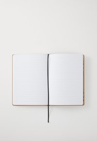 Lærbundet notatbok med linjerte sider, åpen midt i boken. Har et svart bånd som bokmerke og et oransjebrunt omslag med subtil tekstur.