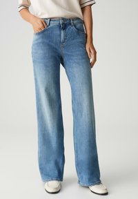 Lichtblauwe wijde jeans van denim. Kenmerken zijn onder andere een hoge taille, vijf zakken en een lichte vervaging aan de voorkant.
