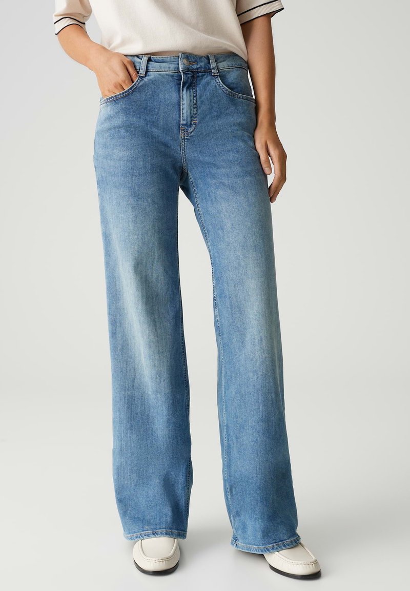 Lichtblauwe wijde jeans van denim. Kenmerken zijn onder andere een hoge taille, vijf zakken en een lichte vervaging aan de voorkant.