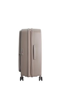 Hardshell suitcase in taupe, featuring a side handle, zipper closure, combination lock, and four wheels for easy mobility.