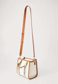 Mala branca com detalhes em pele laranja. Apresenta uma forma estruturada, alça ajustável e um logótipo de marca preto em destaque impresso de lado.