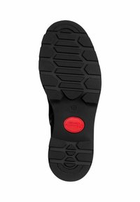 Suela de zapato de goma negra con un patrón hexagonal texturizado, que cuenta con un logo circular rojo en el centro. Diseñada para durabilidad y agarre.