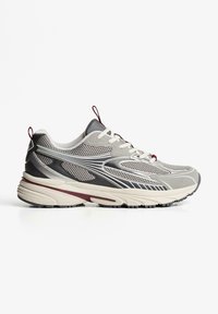 Gray athletic shoe with mesh and synthetic upper, lace closure, pull tab, and durable rubber sole; features silver accents and textured detailing.
