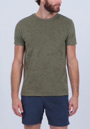 T-shirt olive vert à manches courtes en tissu doux, associé à un short bleu marine. Le T-shirt présente un col rond et une coupe décontractée.