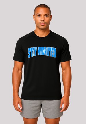 Schwarzes Sport-T-Shirt mit dem Text "STAY HYDRATED" in fettem Blau. Mit Rundhalsausschnitt und kurzen Ärmeln, getragen mit grauen Shorts.