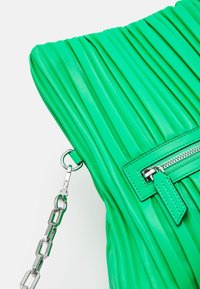 Vihreä poimutettu käsilaukku teksturoidusta nahasta. Varustettu hopeisella ketjuhihnalla ja vetoketjupussilla, jossa on yhteensopiva reunus.