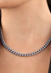 Collana a catena in tono argentato con anelli intrecciati, finitura metallica liscia e design elegante che si appoggia sulla clavicola.