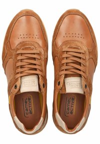 Braune Ledersneaker mit einer Wildlederspitze, perforem Details und weißen Sohlen. Etiketten an Zunge und Seite, mit strukturierten Akzenten.