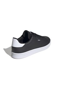 Czarno-biała niska sneaker Adidas z wiązanym wzorem i logo z boku oraz na języku, pokazana z tylnego kąta na białym tle.