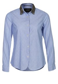 Camicia a maniche lunghe azzurro chiaro con colletto nero a tessuto, chiusura con bottoni e tessuto a motivo con piccole puntini in rilievo.
