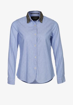 Camicia a maniche lunghe azzurro chiaro con colletto nero a tessuto, chiusura con bottoni e tessuto a motivo con piccole puntini in rilievo.