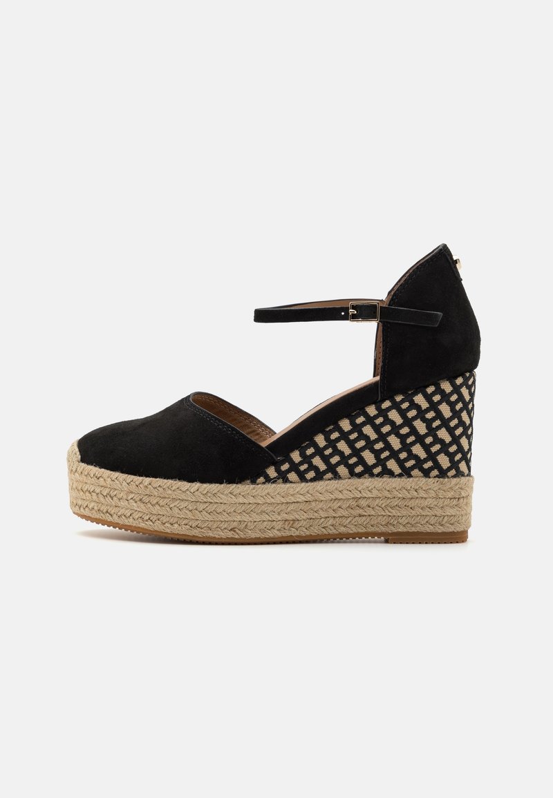 Espadrille compensée en daim noir avec bride à la cheville, semelle plateforme en jute tressé, et motif en treillis noir et beige sur la zone du talon.