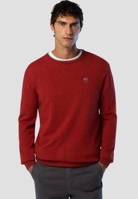 Maglione rosso lavorato a maglia con scollatura rotonda e polsini a coste. Presenta un piccolo logo sul petto e un bordo a contrasto attorno al colletto.