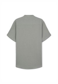 Camicia a maniche corte di colore grigio chiaro, realizzata in tessuto testurizzato, con un fit rilassato e una spalla posteriore per una maggiore struttura.