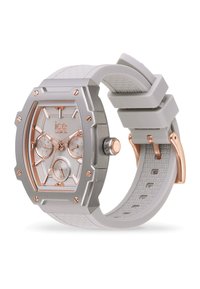 Montre gris clair avec un cadran rectangulaire en argent et or rose, trois sous-cadrans, bracelet en silicone texturé et accents en métal.
