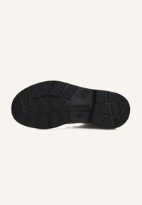 Semelle de chaussure en caoutchouc noir avec motifs de grip texturés, présentant un profil incurvé et une empreinte de logo discrète près du talon.
