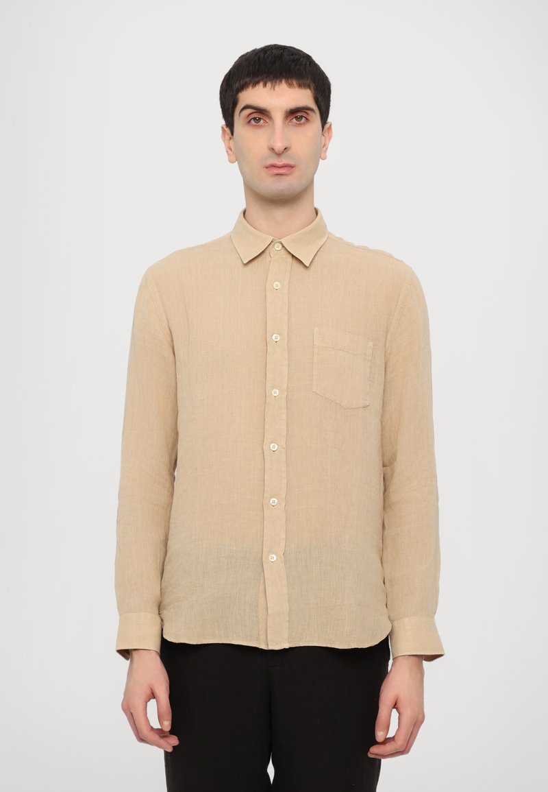 Camicia beige a maniche lunghe realizzata in tessuto testurizzato, con colletto a punta, taschino anteriore e chiusura con bottoni sul davanti.