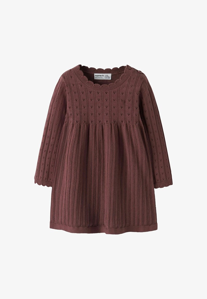 Robe bébé tricotée à manches longues en rose poudré avec bords festonnés et détails ajourés en forme de cœur, fermeture par bouton à l'épaule.