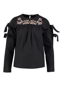 Svart långärmad skjorta med rund halsringning,prydd med blommig broderi fram,och knytning på ärmarna. Mjuk tygkänsla.