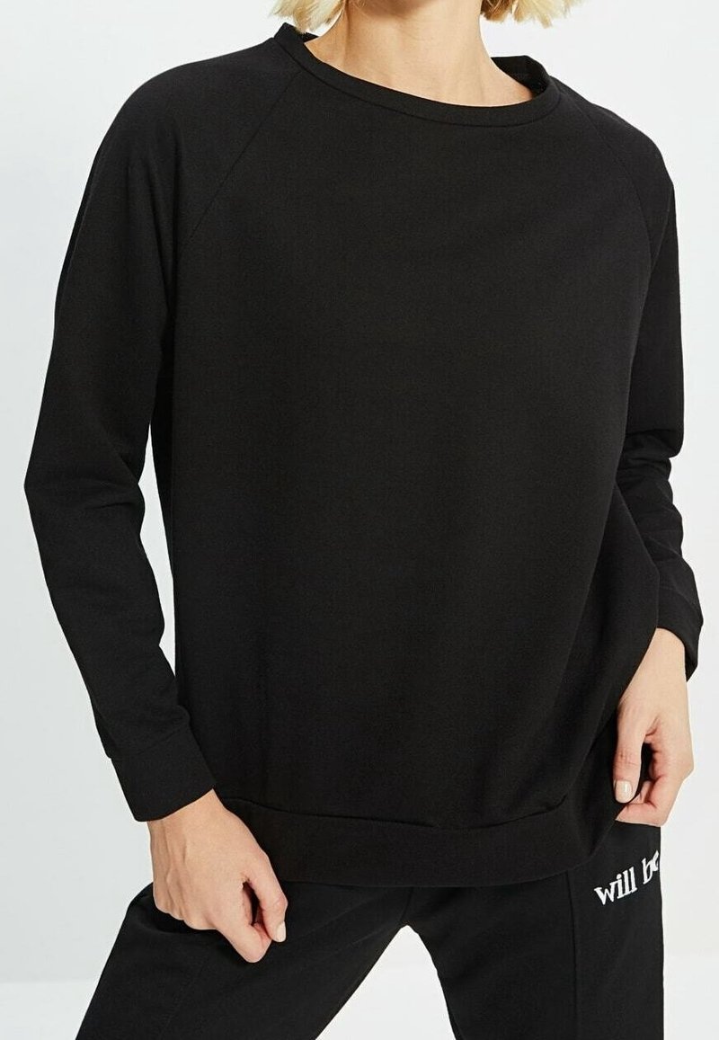 Schwarzes Sweatshirt mit langen Raglanärmeln, rundem Ausschnitt und gerippten Bündchen. Weicher Stoff mit einem entspannten, lockeren Schnitt, der minimale Designdetails aufweist.
